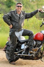 Tall rider wearing brown leather motorcycle jacket with side vents