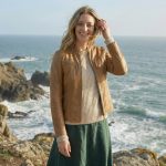 Woman wearing Aurelia tan leather cafe racer jacket styled for coastal casual wear