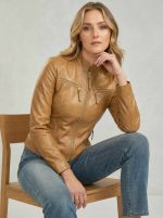 Women's tan leather cafe racer jacket in a seated lifestyle pose, premium lambskin leather